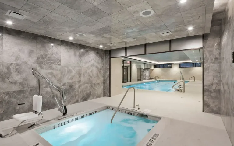Indoor aquatic facility with a hot tub in the foreground labeled 